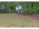 Large backyard features a shed in a treeline and a grass lawn at 2530 River Run Dr, Dacula, GA 30019