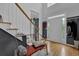 Bright foyer with hardwood floors, white front door, and staircase with gray wall accent and bench at 2530 River Run Dr, Dacula, GA 30019