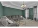 Cozy living room features stylish decor, modern chandelier, and comfortable seating with a glass coffee table at 2530 River Run Dr, Dacula, GA 30019
