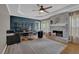 Stylish home office with a brick fireplace, dark blue accent wall, and ample natural light at 2530 River Run Dr, Dacula, GA 30019