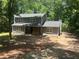 Charming two-story home with gray siding and a stone accent front porch, nestled among mature trees at 6743 Timbers East Dr, Lithonia, GA 30058