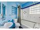 Blue bathroom with decorative tiles, a bathtub, shower and glass block window at 850 Fourth St, Stone Mountain, GA 30083