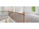 View of the second floor hallway with iron railings and neutral carpet at 1452 Stephens View Dr, Loganville, GA 30052