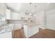 Stylish kitchen with granite counters, island, shaker cabinets, and modern pendant lighting at 1452 Stephens View Dr, Loganville, GA 30052