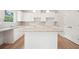 Bright kitchen featuring white cabinetry, an island, and modern pendant lighting at 1452 Stephens View Dr, Loganville, GA 30052
