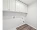 A laundry room with wood-look floors and white upper cabinets at 1452 Stephens View Dr, Loganville, GA 30052