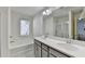 Bright bathroom featuring dual sinks, a soaking tub, and a separate shower at 2132 Arnage Dr, Lithonia, GA 30058
