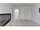 A simple bedroom with neutral carpet and white walls with a TV on the wall and a view into a hallway at 2132 Arnage Dr, Lithonia, GA 30058