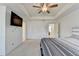 This bedroom features a ceiling fan, TV, and neutral carpet at 2132 Arnage Dr, Lithonia, GA 30058