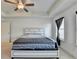 Bright bedroom featuring a tray ceiling, ceiling fan, and large window at 2132 Arnage Dr, Lithonia, GA 30058