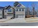Attractive townhome with a gray brick exterior, two-car garage, and well-maintained landscaping at 2132 Arnage Dr, Lithonia, GA 30058