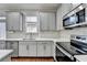 Beautiful kitchen with stainless appliances, gray cabinets, and stone backsplash at 2132 Arnage Dr, Lithonia, GA 30058