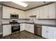 Modern kitchen with stainless steel appliances, white cabinets, and dark countertops at 3474 Kingswood Run, Decatur, GA 30034