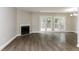 Spacious living room featuring hardwood floors, a fireplace, and access to the backyard through French doors at 3474 Kingswood Run, Decatur, GA 30034