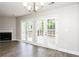 Bright living room featuring hardwood floors, a fireplace, and access to the backyard through French doors at 3474 Kingswood Run, Decatur, GA 30034
