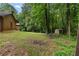 A picturesque backyard with a rustic log cabin, lush trees, and a cozy outdoor seating area at 6605 Old White Mill Rd, Fairburn, GA 30213