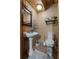 Cozy half bath with a classic pedestal sink, toilet, framed mirror and neutral walls at 6605 Old White Mill Rd, Fairburn, GA 30213