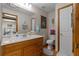 Bright bathroom featuring oak vanity, framed mirror, and tile flooring at 6605 Old White Mill Rd, Fairburn, GA 30213