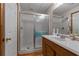 Bathroom featuring walk-in shower with frameless glass enclosure and oak vanity at 6605 Old White Mill Rd, Fairburn, GA 30213