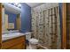 Bathroom with blue walls, a shower with a themed curtain, and a wooden cabinet sink at 6605 Old White Mill Rd, Fairburn, GA 30213