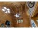 High vaulted ceiling with wood beams, a ceiling fan, and chandeliers creating an airy, rustic ambiance at 6605 Old White Mill Rd, Fairburn, GA 30213