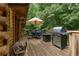 Outdoor deck with a grill, seating, and umbrella, ideal for gatherings with views of surrounding trees at 6605 Old White Mill Rd, Fairburn, GA 30213