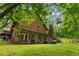 The lower-level exterior features a log cabin design, walkout, and steps to the lush, green backyard at 6605 Old White Mill Rd, Fairburn, GA 30213