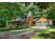 Charming log home with a two-car garage nestled in a wooded setting and featuring a welcoming front porch at 6605 Old White Mill Rd, Fairburn, GA 30213