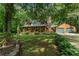 Charming log home with a covered front porch and beautifully landscaped yard at 6605 Old White Mill Rd, Fairburn, GA 30213