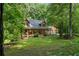 Attractive log home with a covered porch, nestled among trees on a spacious lot at 6605 Old White Mill Rd, Fairburn, GA 30213