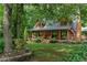 Well-maintained log home featuring a covered front porch with rocking chairs and lovely landscaping at 6605 Old White Mill Rd, Fairburn, GA 30213