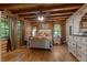 Inviting bedroom with wood walls, wood floors, dresser and a cozy bed at 6605 Old White Mill Rd, Fairburn, GA 30213