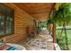 Inviting front porch with a swing and rocking chairs, offering a relaxing outdoor space with log siding at 6605 Old White Mill Rd, Fairburn, GA 30213