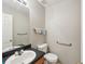 Cozy bathroom featuring a pedestal sink, toilet, and grab bars for added accessibility and convenience at 701 Fir Chase, Fairburn, GA 30213