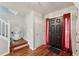 Bright entryway featuring hardwood floors, stair lift, and red curtains flanking a black front door at 701 Fir Chase, Fairburn, GA 30213