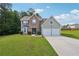 Charming two-story home featuring a brick facade, two-car garage, and a lush green lawn at 701 Fir Chase, Fairburn, GA 30213