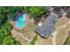 Aerial view of a home with a pool, and a long driveway surrounded by green trees at 12 Blackfoot Trl, Sharpsburg, GA 30277