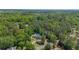 A distant aerial view of a home surrounded by a dense forest of green trees at 12 Blackfoot Trl, Sharpsburg, GA 30277