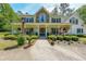 Charming two-story home with stone accents, a welcoming front porch, and lush landscaping at 12 Blackfoot Trl, Sharpsburg, GA 30277