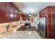 Beautiful kitchen with dark wood cabinets, granite countertops, stainless steel appliances and tile backsplash at 12 Blackfoot Trl, Sharpsburg, GA 30277