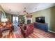 Spacious living room with a fireplace, hardwood floors, and a large TV for entertainment at 12 Blackfoot Trl, Sharpsburg, GA 30277