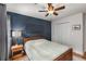 Comfortable bedroom with a dark blue accent wall, a ceiling fan, and wood floors at 1341 Sheffield Glen Ne Way, Atlanta, GA 30329