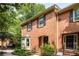 Two-story brick townhome with bay windows, dark shutters and well-maintained front landscaping at 1341 Sheffield Glen Ne Way, Atlanta, GA 30329