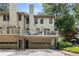 Rear exterior view of home with multi-level deck, garages and lush green surroundings at 1341 Sheffield Glen Ne Way, Atlanta, GA 30329