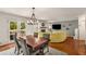 Open living and dining area with hardwood floors and natural light, and a yellow corner sofa at 1341 Sheffield Glen Ne Way, Atlanta, GA 30329