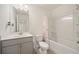 A clean bathroom featuring a shower with curtain, gray vanity, and a modern light fixture at 3075 Westpoint Cir, Snellville, GA 30078