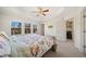Bright bedroom with carpet, tray ceilings, ceiling fan, and a view of trees at 3075 Westpoint Cir, Snellville, GA 30078