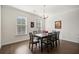 Formal dining room with modern chandelier, hardwood floors, and natural light from large windows at 3075 Westpoint Cir, Snellville, GA 30078