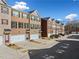 A row of brick townhomes, each featuring a single-car garage and driveway at 3075 Westpoint Cir, Snellville, GA 30078
