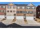 Row of townhomes with brick facades, driveways, and individual single-car garages at 3075 Westpoint Cir, Snellville, GA 30078